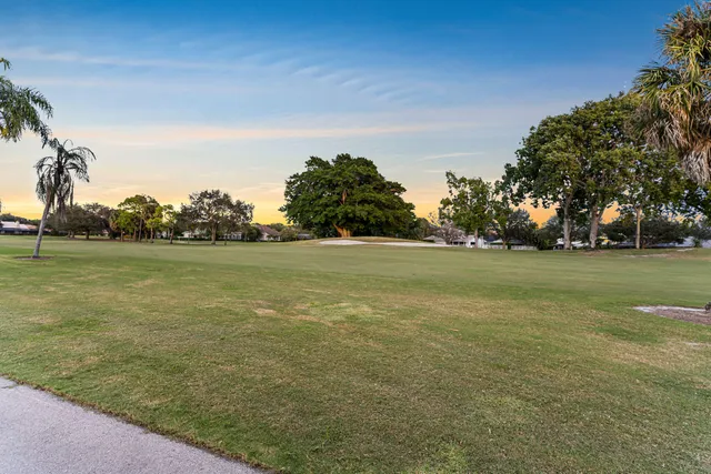a view of a green field with wooden fence