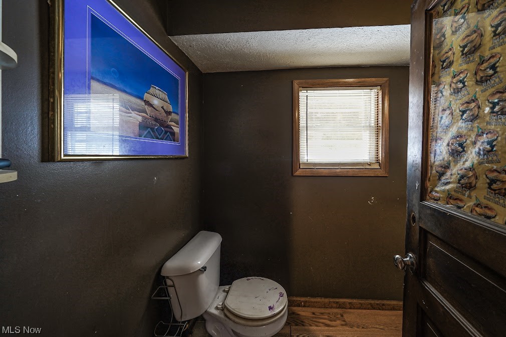 9606 Durst Colebrook Road North Bloomfield, OH 44450 - Photo 11 of 24 Bathroom with hardwood / wood-style floors, toilet, and a textured ceiling