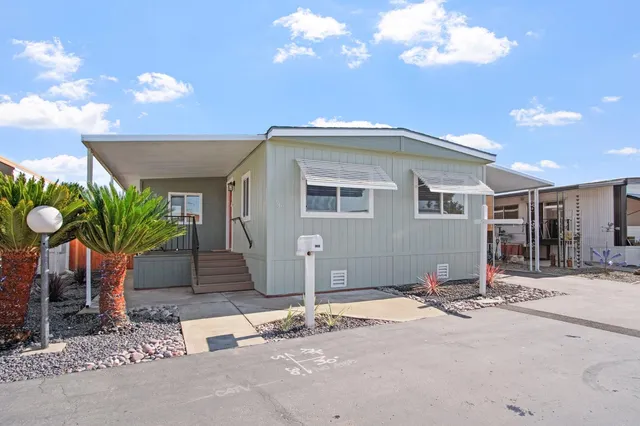 a front view of a house with a yard and glass space