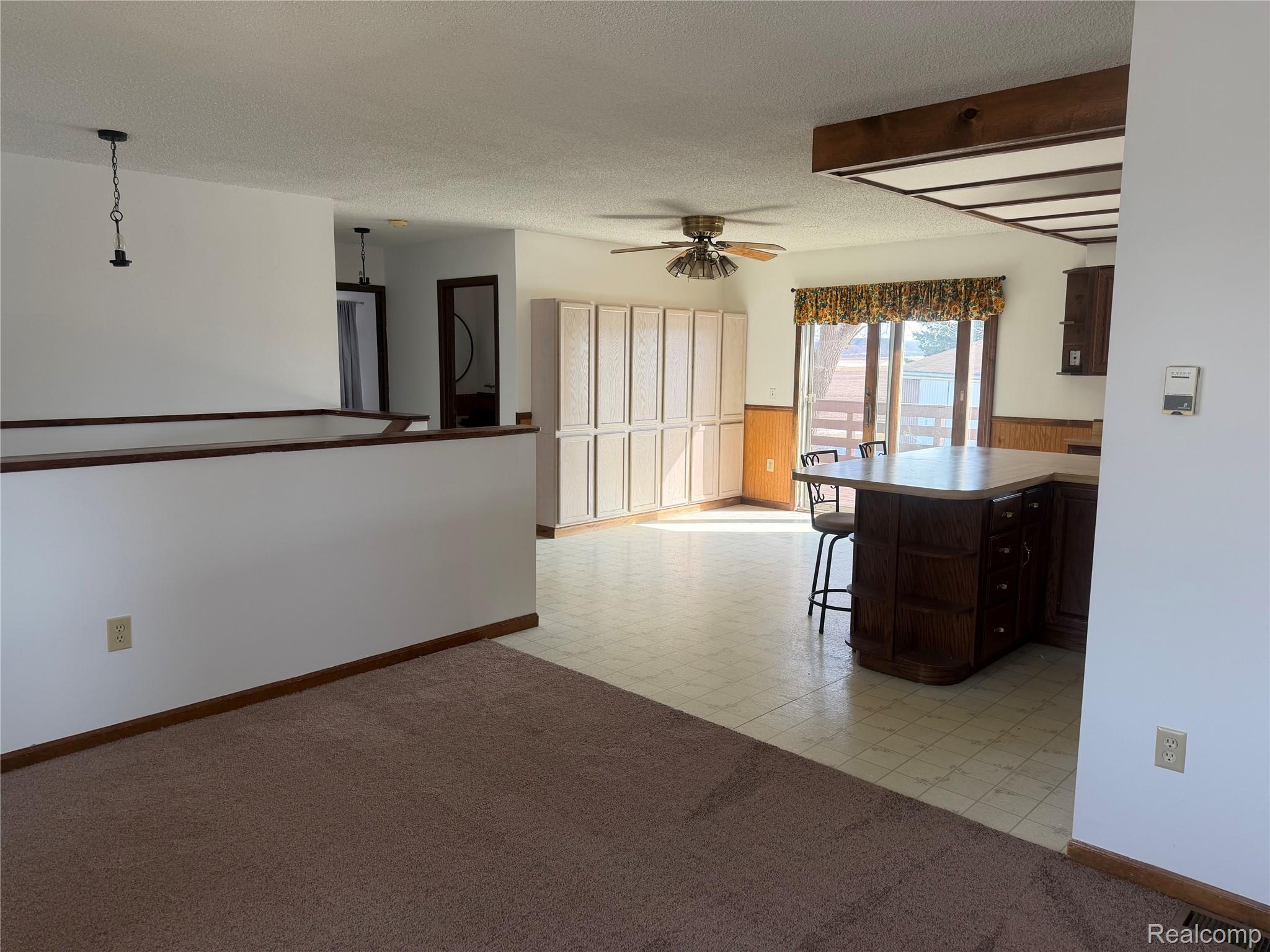 5749 Leix Road Mayville, MI 48744 - Photo 22 of 44 Kitchen with a breakfast bar area, ceiling fan, light colored carpet, a peninsula, and a textured ceiling