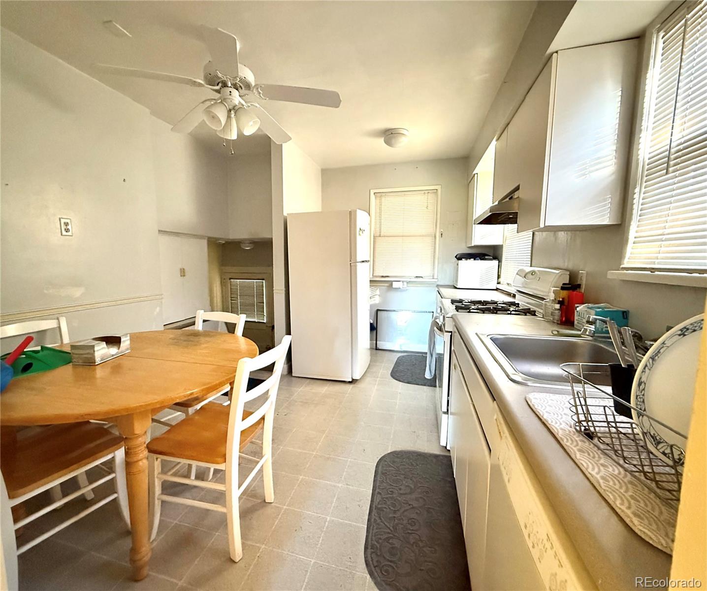 1440 South Race Street Denver, CO 80210 - Photo 16 of 17 a kitchen with a table chairs refrigerator and cabinets