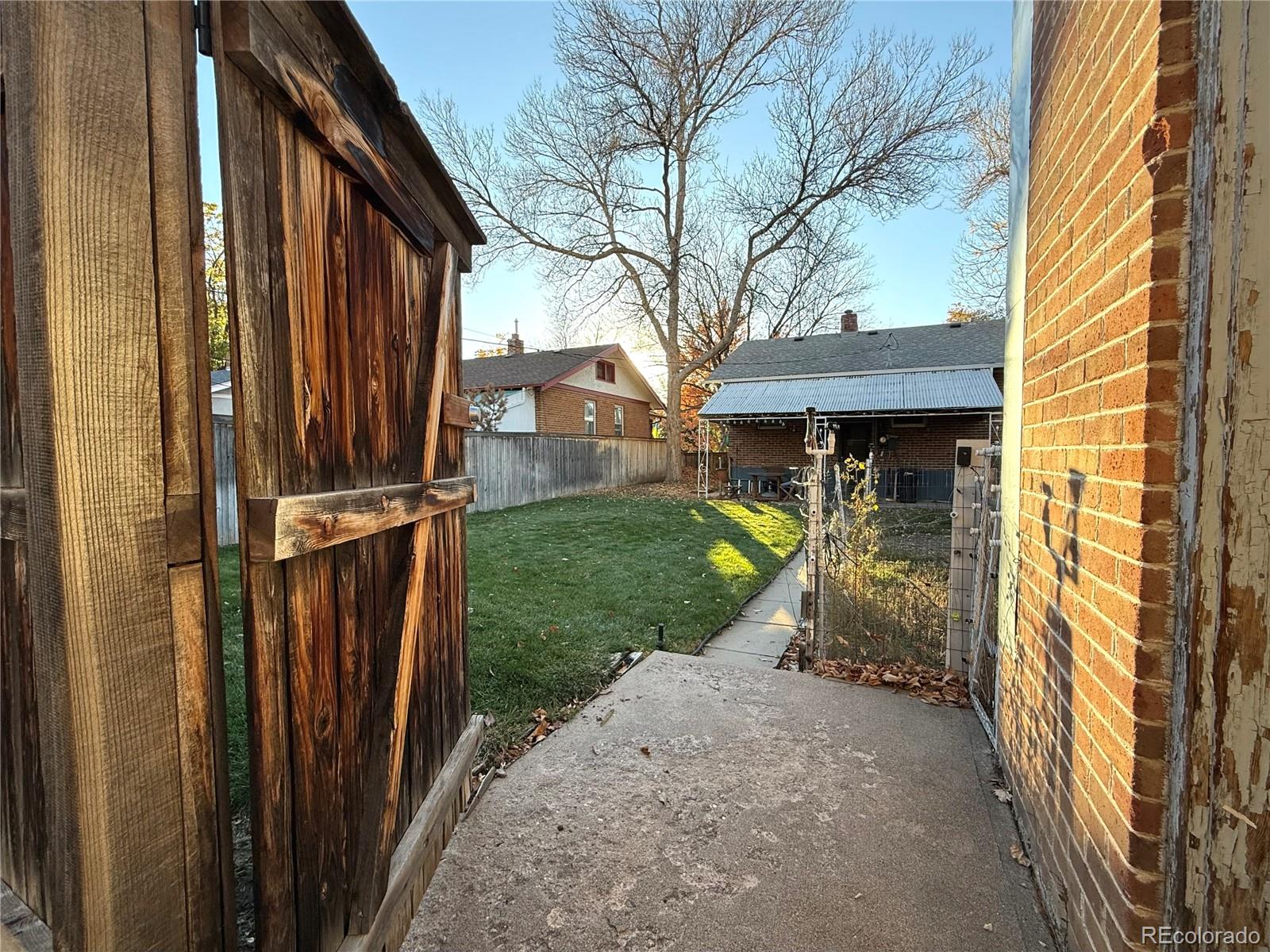1440 South Race Street Denver, CO 80210 - Photo 8 of 17 a view of a house with a small yard and wooden fence