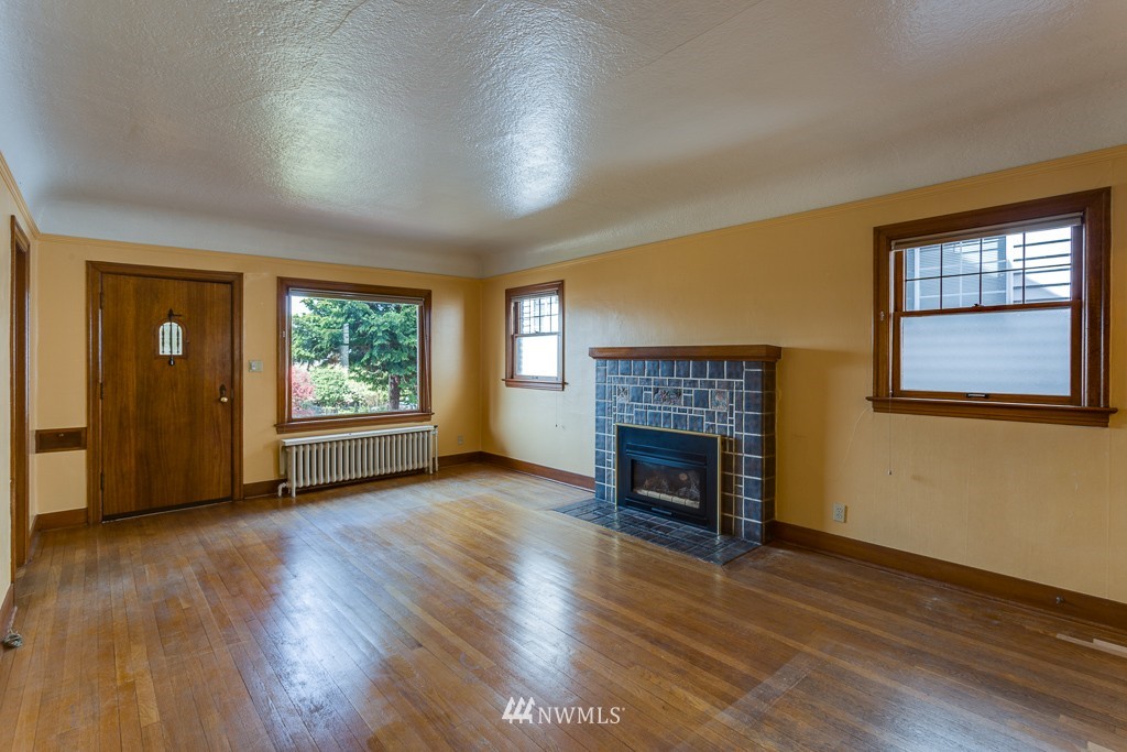 2609 Rucker Avenue Everett, WA 98201 - Photo 3 of 15 an empty room with fireplace wooden floor and windows