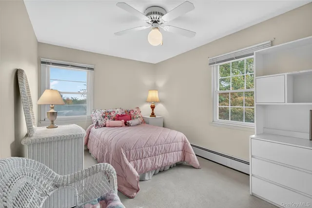 a bedroom with a bed a chandelier and dresser