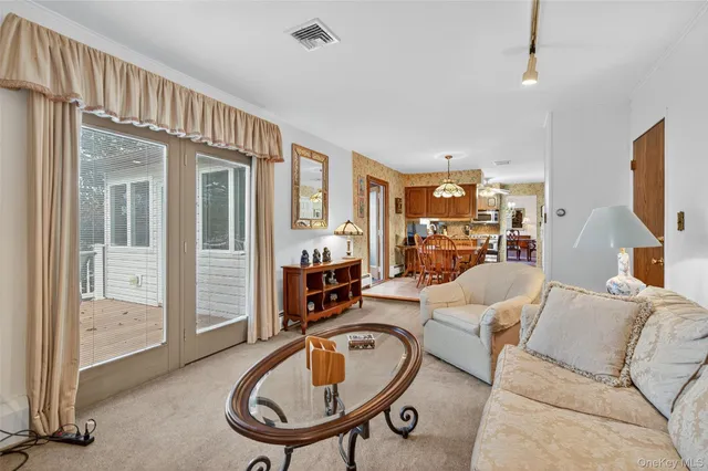 a living room with furniture a flat screen tv and a large window