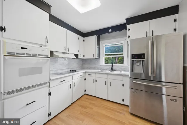 a kitchen with stainless steel appliances a refrigerator sink and microwave