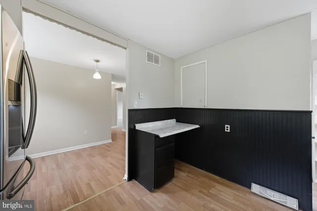 a kitchen with a sink a refrigerator and wooden floor