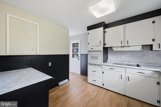 a kitchen with stainless steel appliances cabinets and wooden floor
