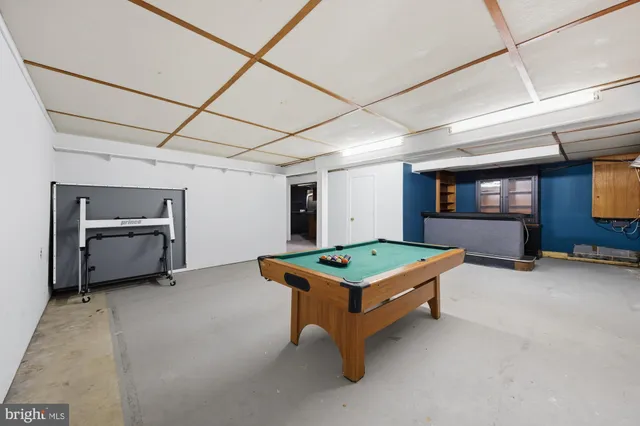 a room with pool table and windows