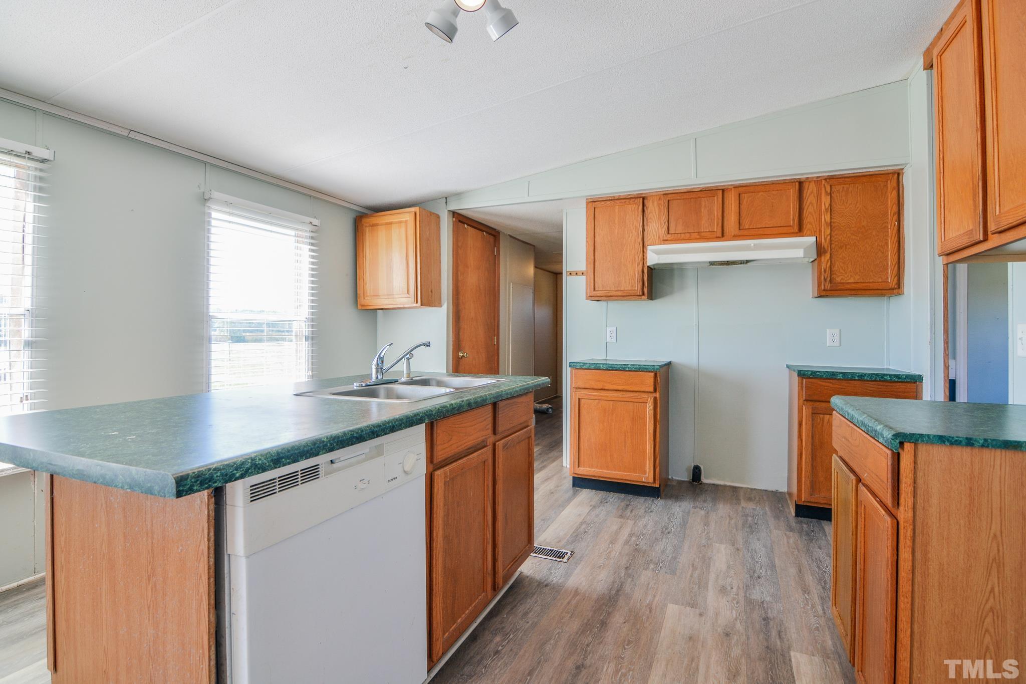 141 Wilson Road Lucama, NC 27851 - Photo 8 of 23 a kitchen with stainless steel appliances granite countertop wooden floors and white cabinets