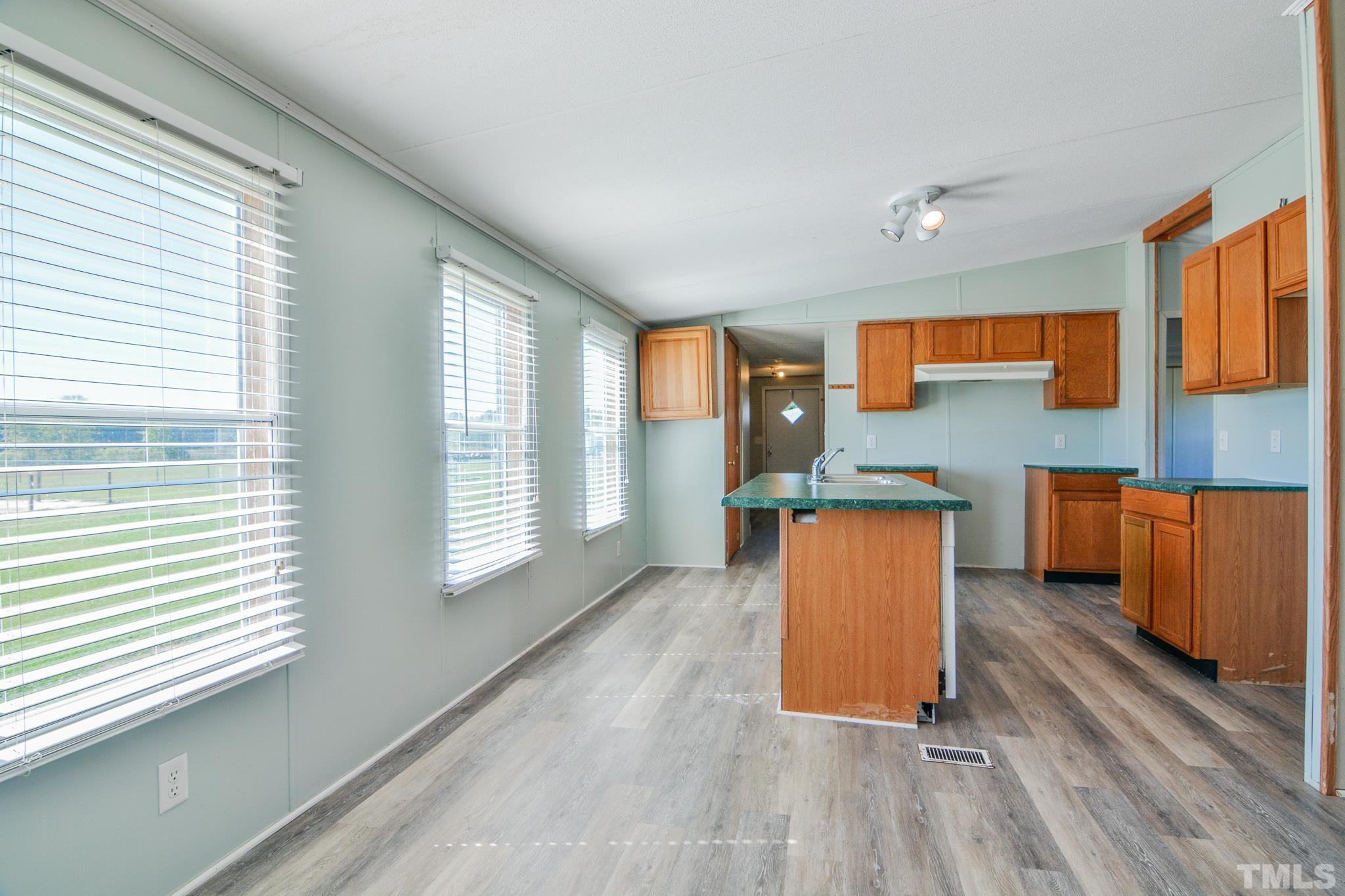 141 Wilson Road Lucama, NC 27851 - Photo 9 of 23 a kitchen with stainless steel appliances granite countertop a sink a stove top oven and wooden floors