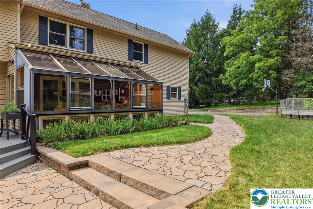 1553 Surrey Road Bethlehem, PA 18015 - Photo 67 of 92 A charming sunroom addition enhances this home's exterior, offering abundant natural light and seamless outdoor access.