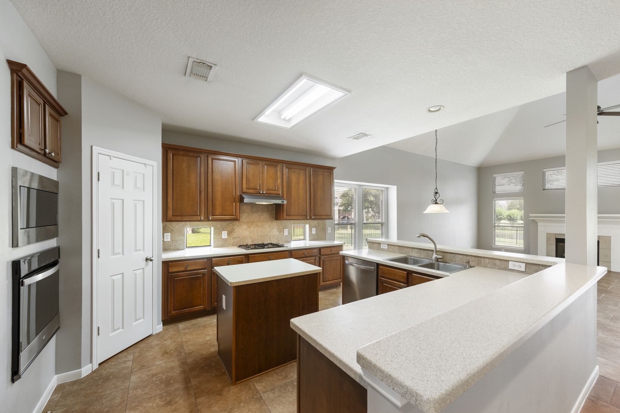 2907 Stemwood Drive Spring, TX 77388 - Photo 6 of 33 Spacious kitchen features rich wood cabinetry, expansive countertops, center island, stainless steel appliances, and an open layout overlooking the living area with serene waterfront views.