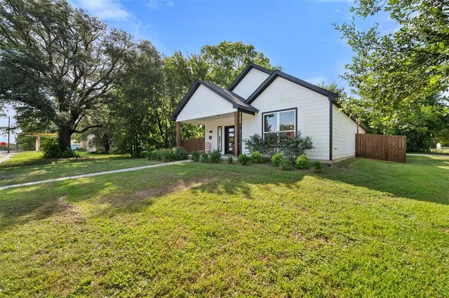 a view of a house with a big yard and large trees