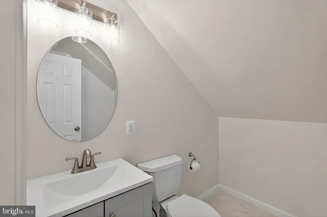 a bathroom with a sink mirror and toilet