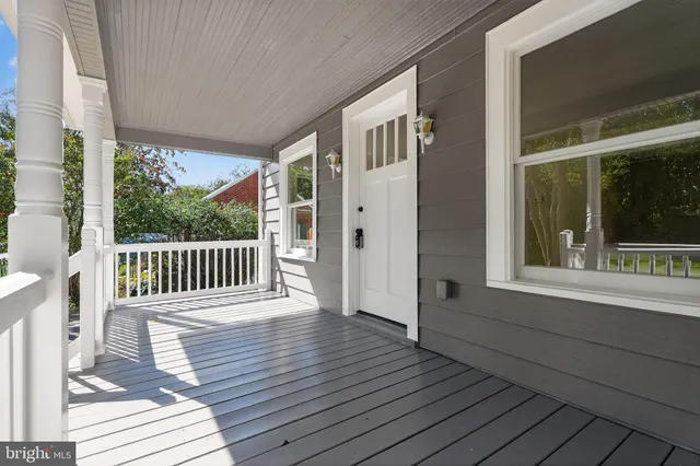 a porch with wooden floor in front of a house