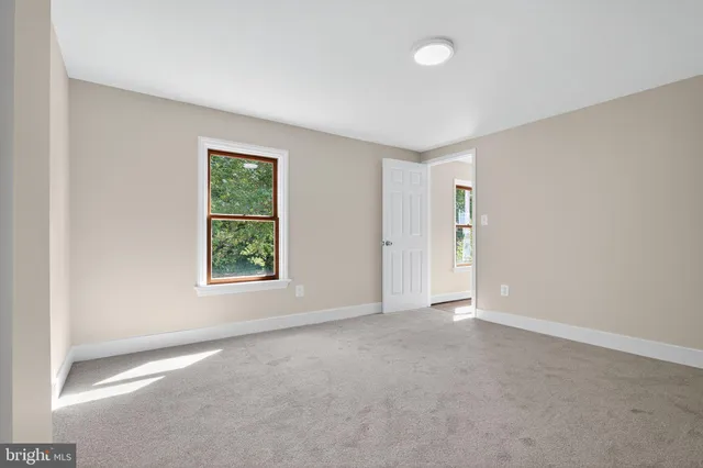 an empty room with windows and closet