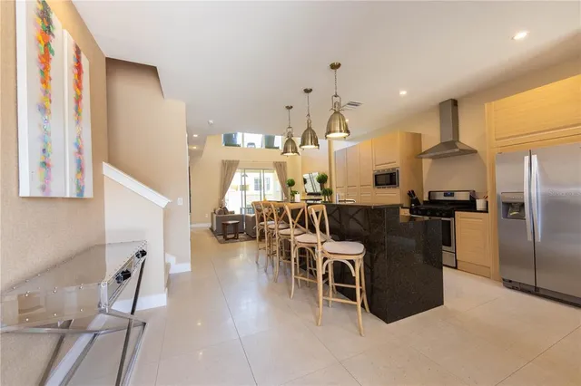 a kitchen with stainless steel appliances kitchen island granite countertop a refrigerator and microwave