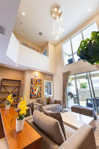 a living room with furniture chandelier and a large window
