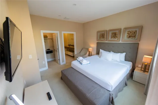 a spacious bedroom with a bed and a flat screen tv