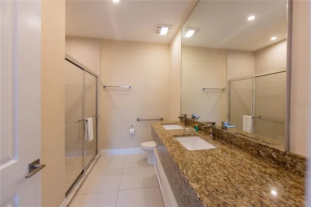 a bathroom with a granite countertop sink a mirror and a shower