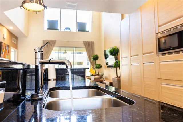a kitchen with a sink and a view of living room