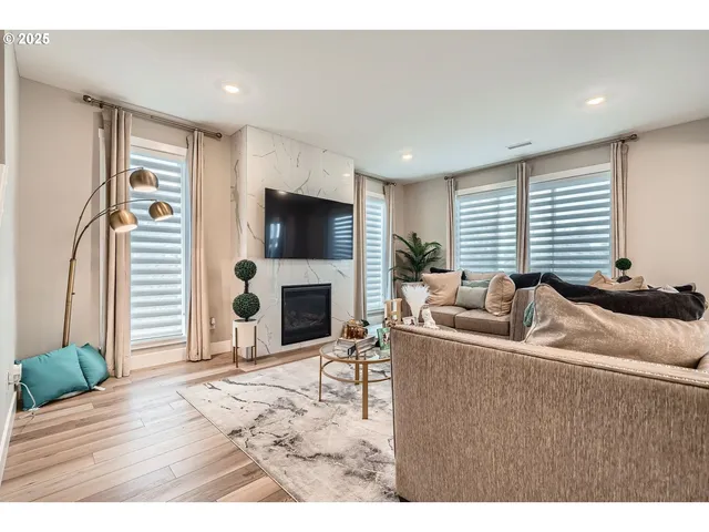 a living room with furniture a flat screen tv and a fireplace