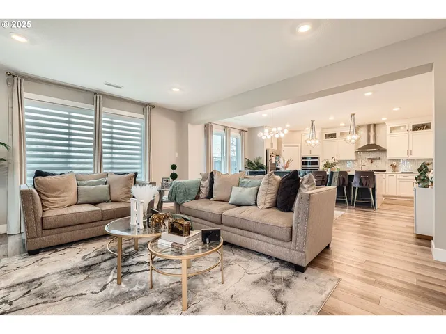 a living room with furniture wooden floor and a large window
