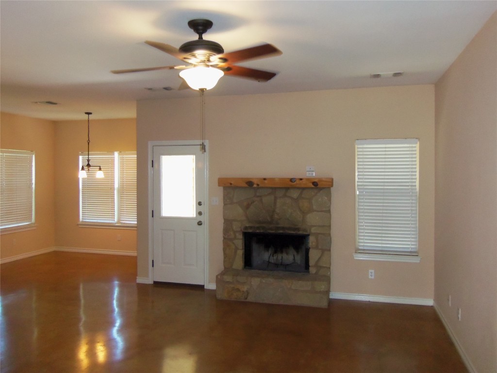 10611 Lake Beach Drive Dripping Springs, TX 78620 - Photo 4 of 22 a view of a livingroom with a fireplace a chandelier and windows