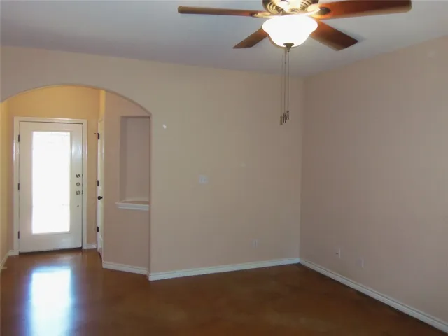 a view of a room with wooden floor and a chandelier fan