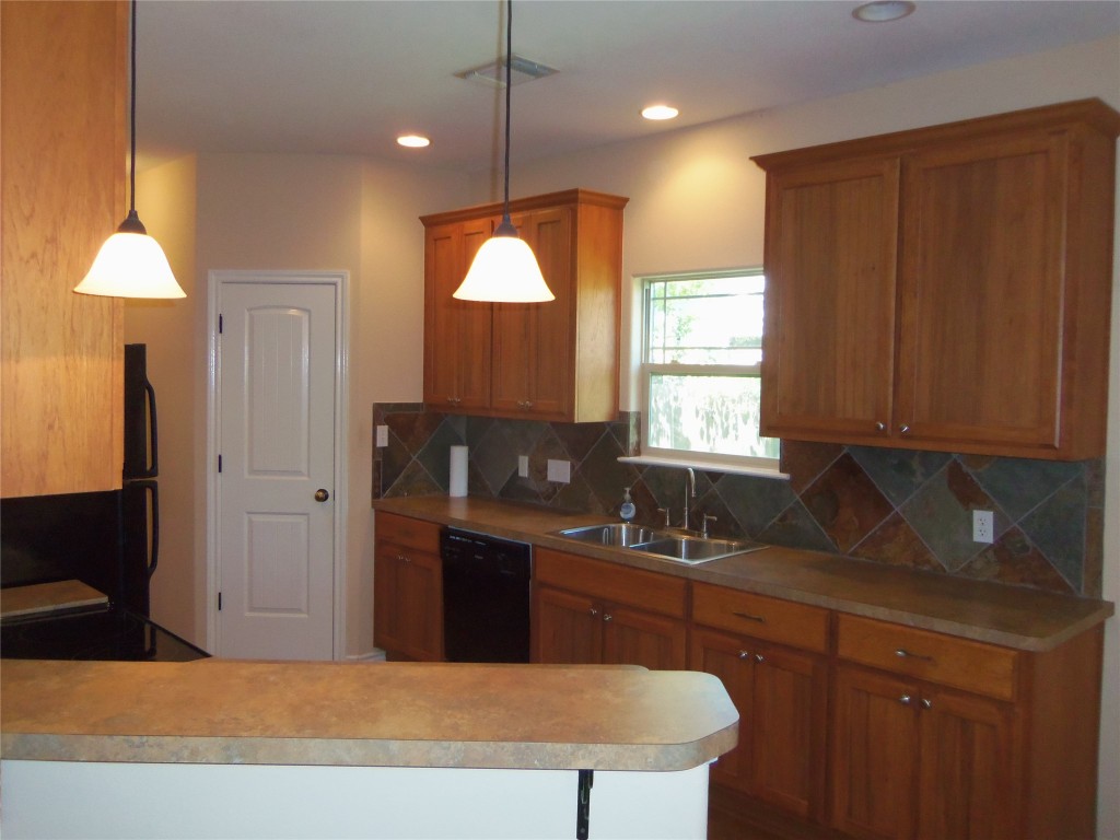 10611 Lake Beach Drive Dripping Springs, TX 78620 - Photo 7 of 22 a kitchen with granite countertop a sink cabinets and window