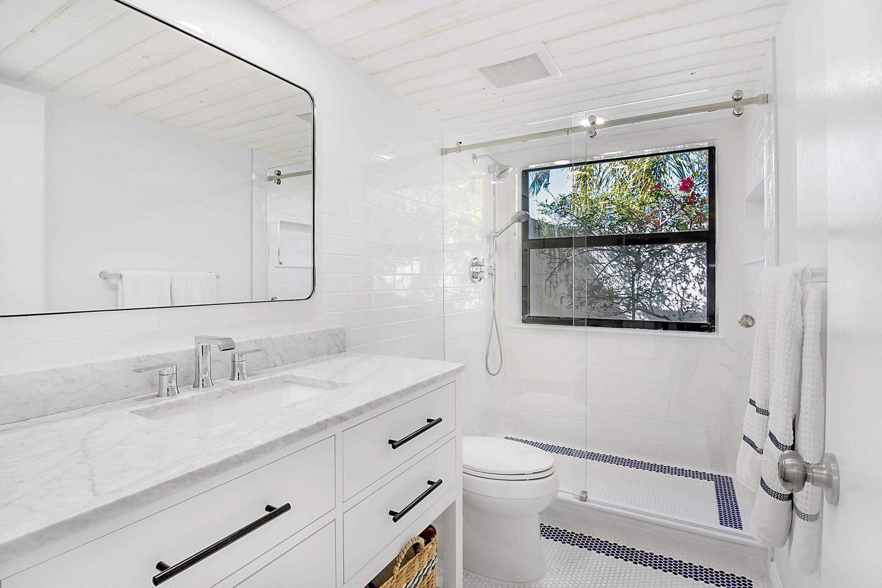 709 Irwin Lane Jupiter, FL 33458 - Photo 17 of 37 a bathroom with a toilet a sink and mirror