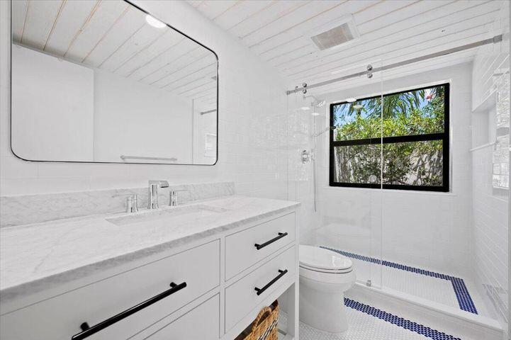 709 Irwin Lane Jupiter, FL 33458 - Photo 24 of 37 a bathroom with a toilet a sink and mirror