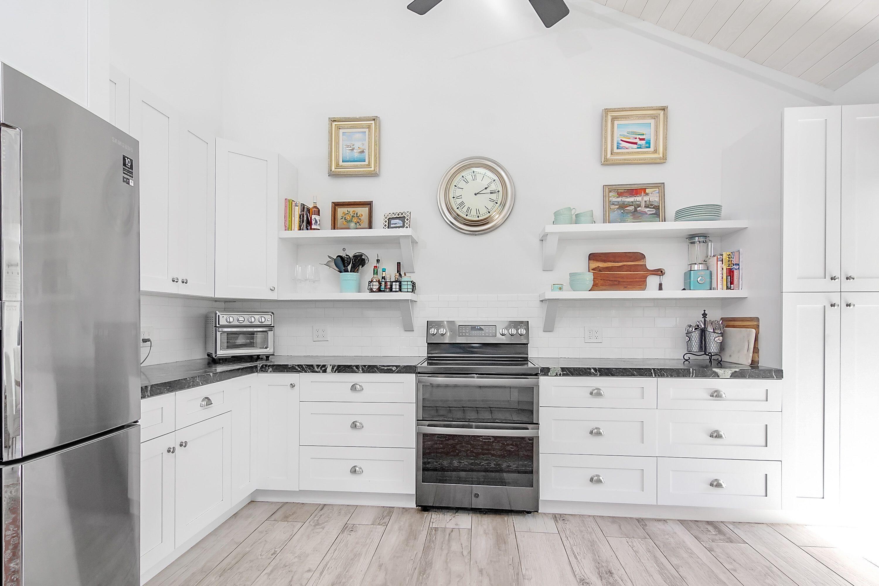 709 Irwin Lane Jupiter, FL 33458 - Photo 7 of 37 a kitchen with granite countertop a cabinets and clock on the wall