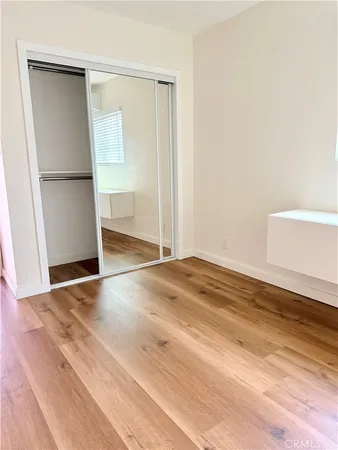 an empty room with wooden floor sink and closet