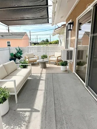 a living room with patio furniture and a floor to ceiling window