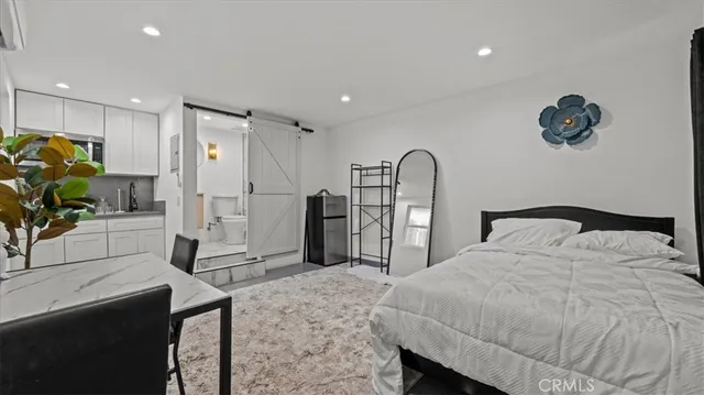 a spacious bedroom with a bed a mirror and desk