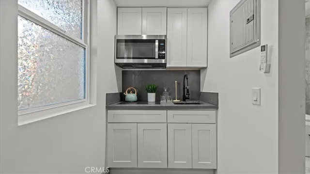 a kitchen with white cabinets and appliances