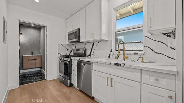 a kitchen with stainless steel appliances a sink stove and cabinets