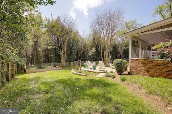 a view of a backyard with plants and wooden fence