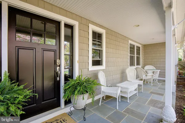 a front view of a house with yard covered with large trees