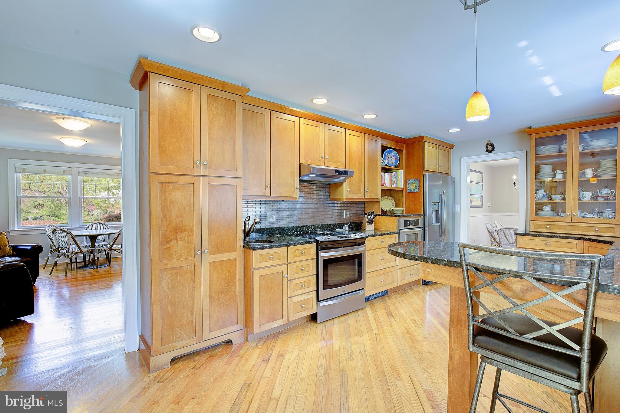 2 Isaacs Street Annapolis, MD 21401 - Photo 35 of 63 a kitchen with stainless steel appliances granite countertop a refrigerator oven stove a dining table and chairs with wooden floor