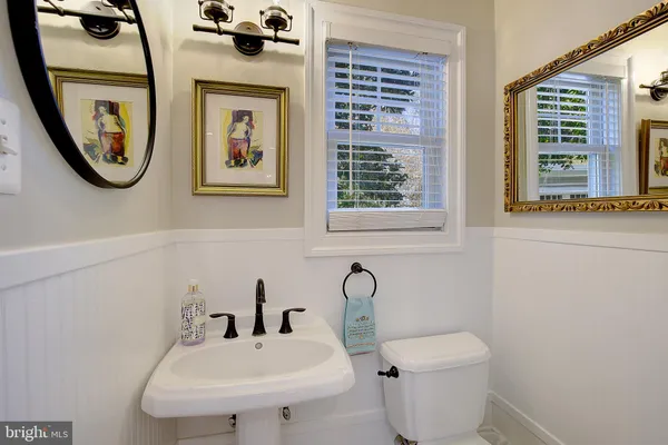 a bathroom with a granite countertop sink mirror vanity bathtub and toilet