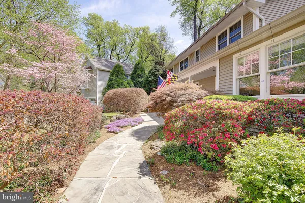 a view of house with yard and trees in the background