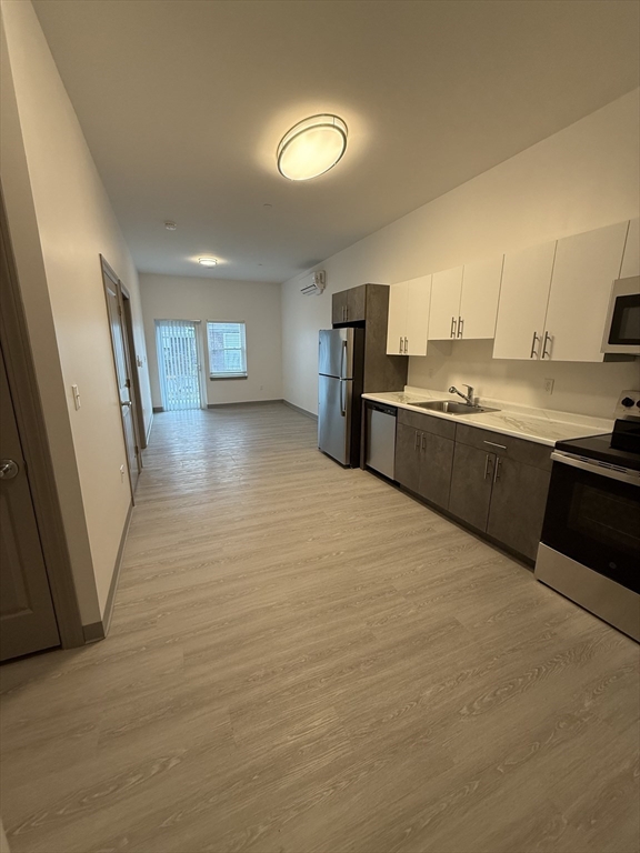 626 Main Street, Unit 105 Dennis, MA 02639 - Photo 5 of 17 a large kitchen with a lot of counter space and wooden floor