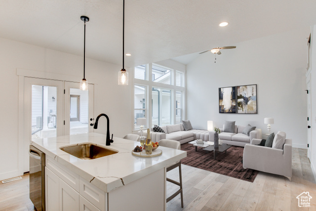 5349 Murray Rdg Road, Unit 135 Murray, UT 84123 - Photo 1 of 1 Kitchen featuring stainless steel dishwasher, sink, white cabinetry, hanging light fixtures, and an island with sink