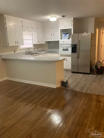 a kitchen with granite countertop a refrigerator and a stove top oven
