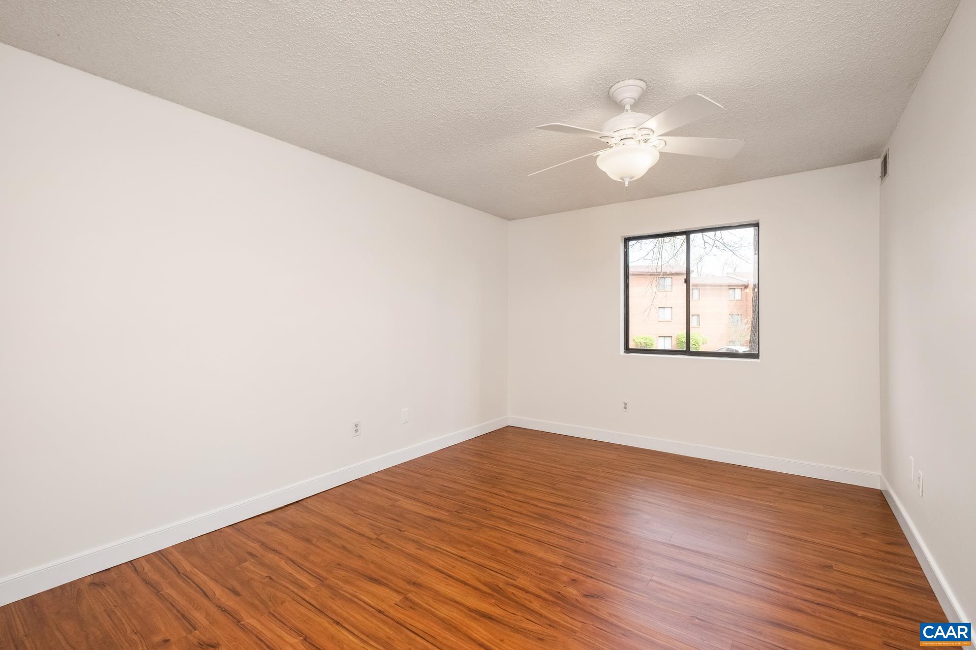 103 Turtle Creek Road, Unit 2 Charlottesville, VA 22901 - Photo 12 of 24 an empty room with wooden floor fan and windows