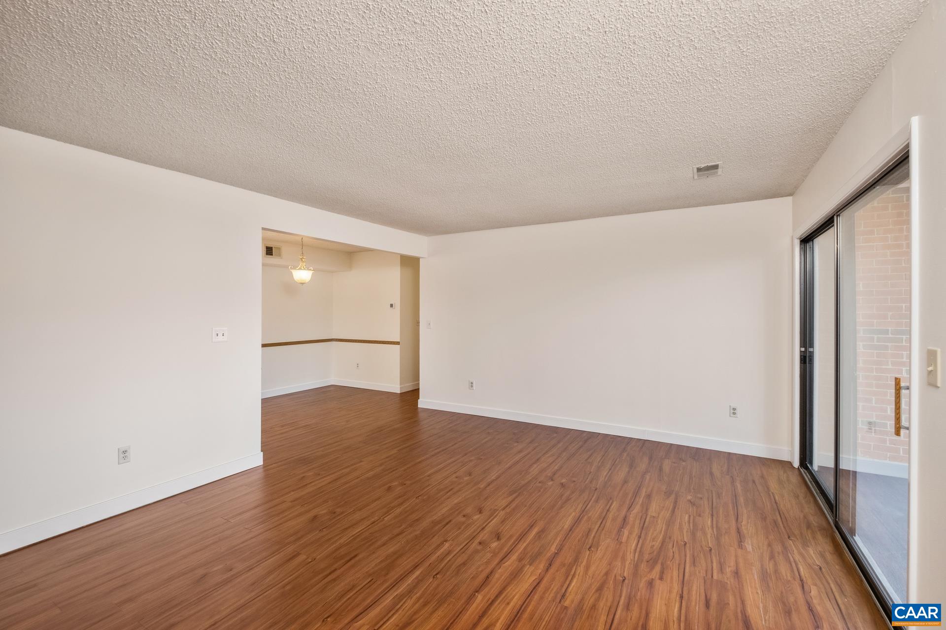 103 Turtle Creek Road, Unit 2 Charlottesville, VA 22901 - Photo 6 of 24 an empty room with wooden floor and windows