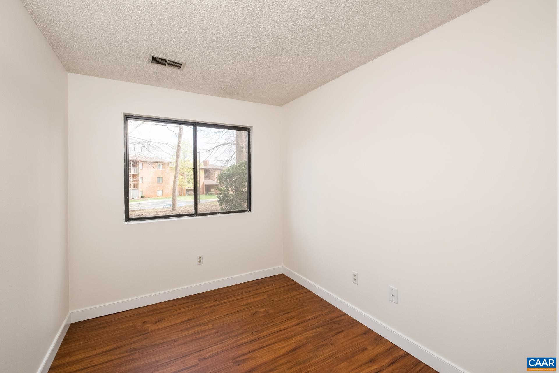 103 Turtle Creek Road, Unit 2 Charlottesville, VA 22901 - Photo 9 of 24 an empty room with wooden floor and windows